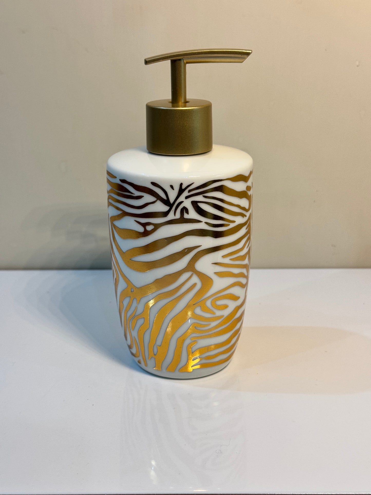Ceramic soap dispenser with a sturdy metal pump and bold tiger print design.