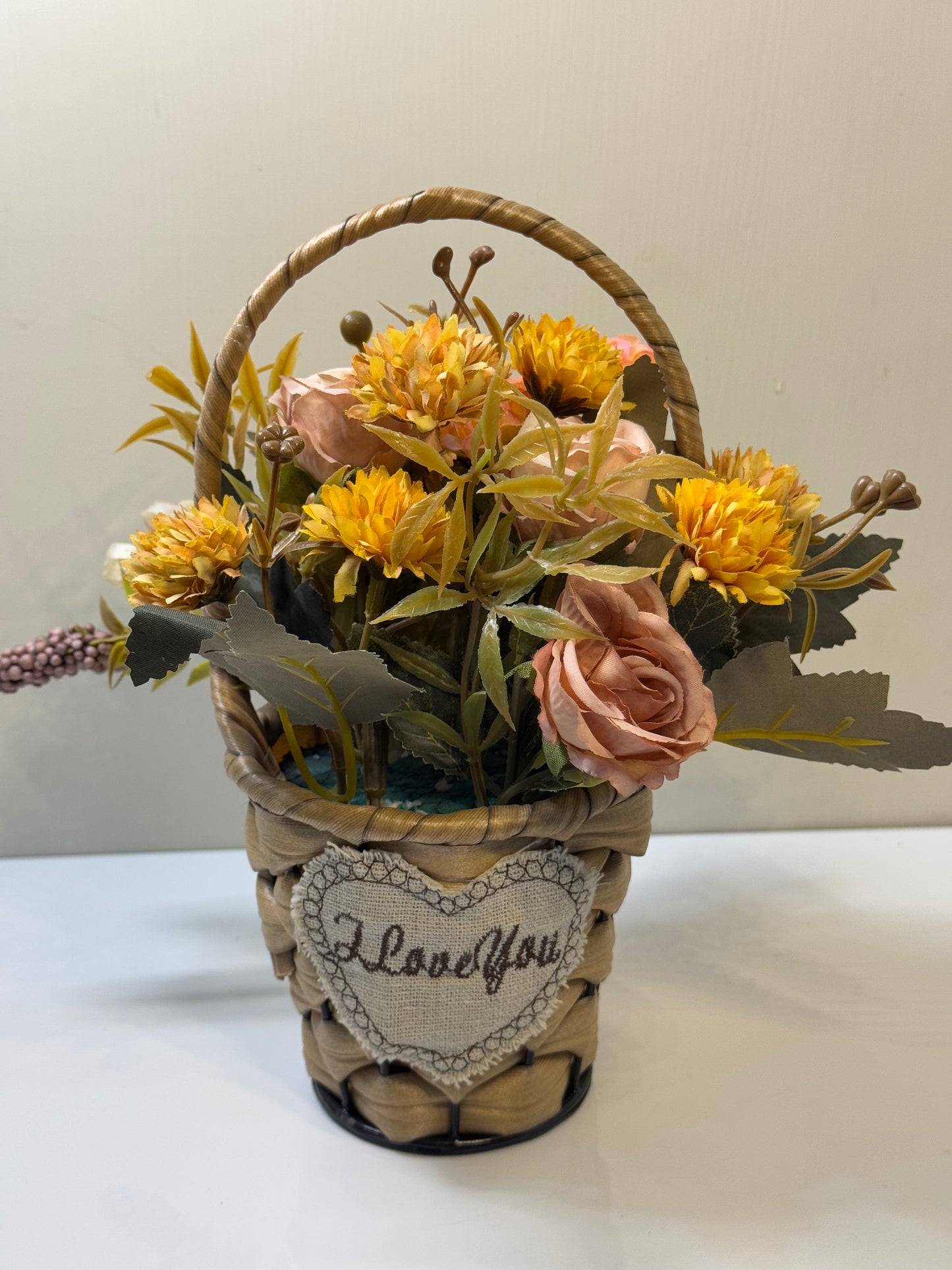 Close-up of the vibrant artificial flowers in the mini round basket, showcasing the variety and details.