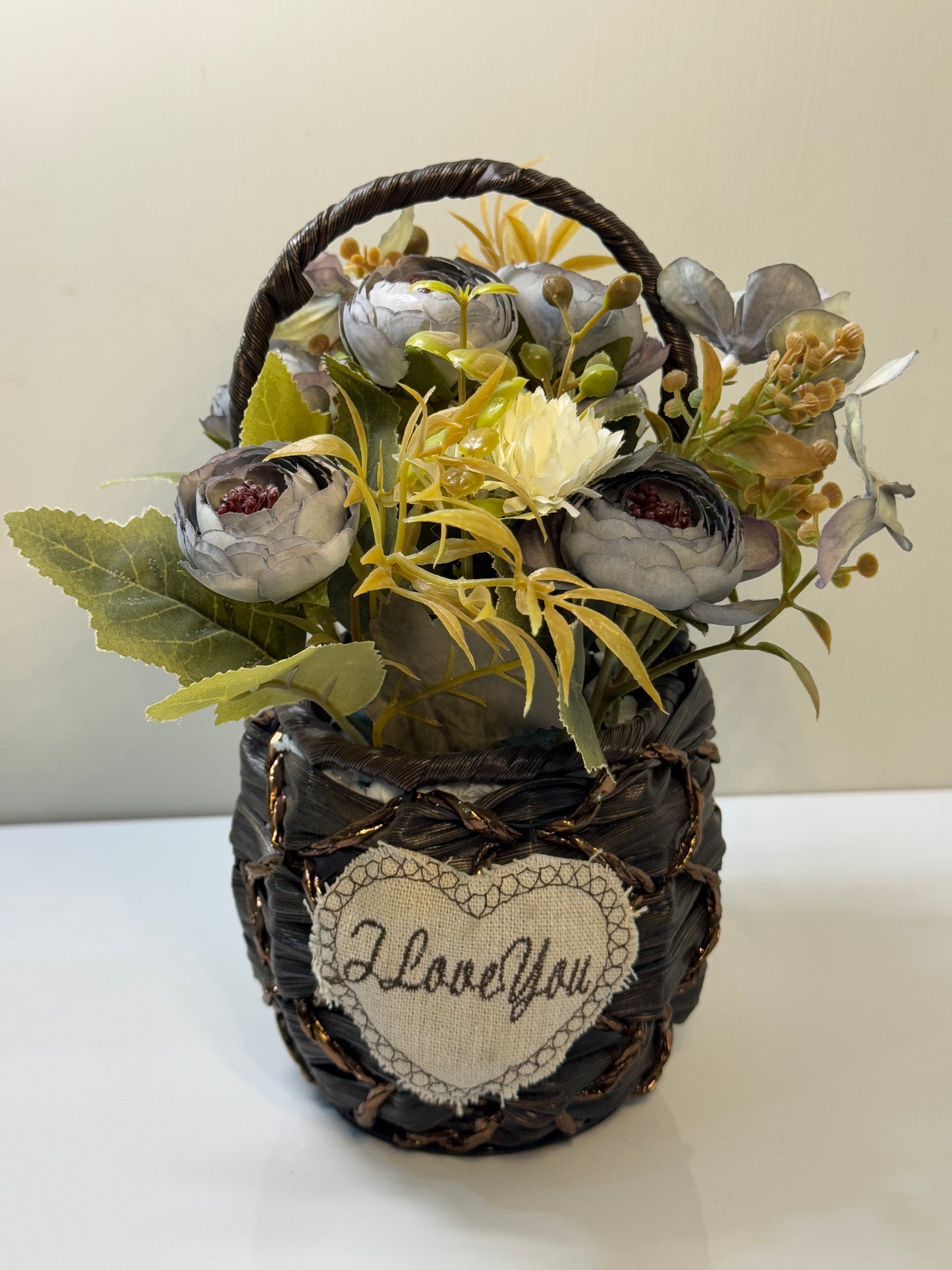 Close-up of the vibrant artificial flowers in the small round basket, showcasing the variety and details.
