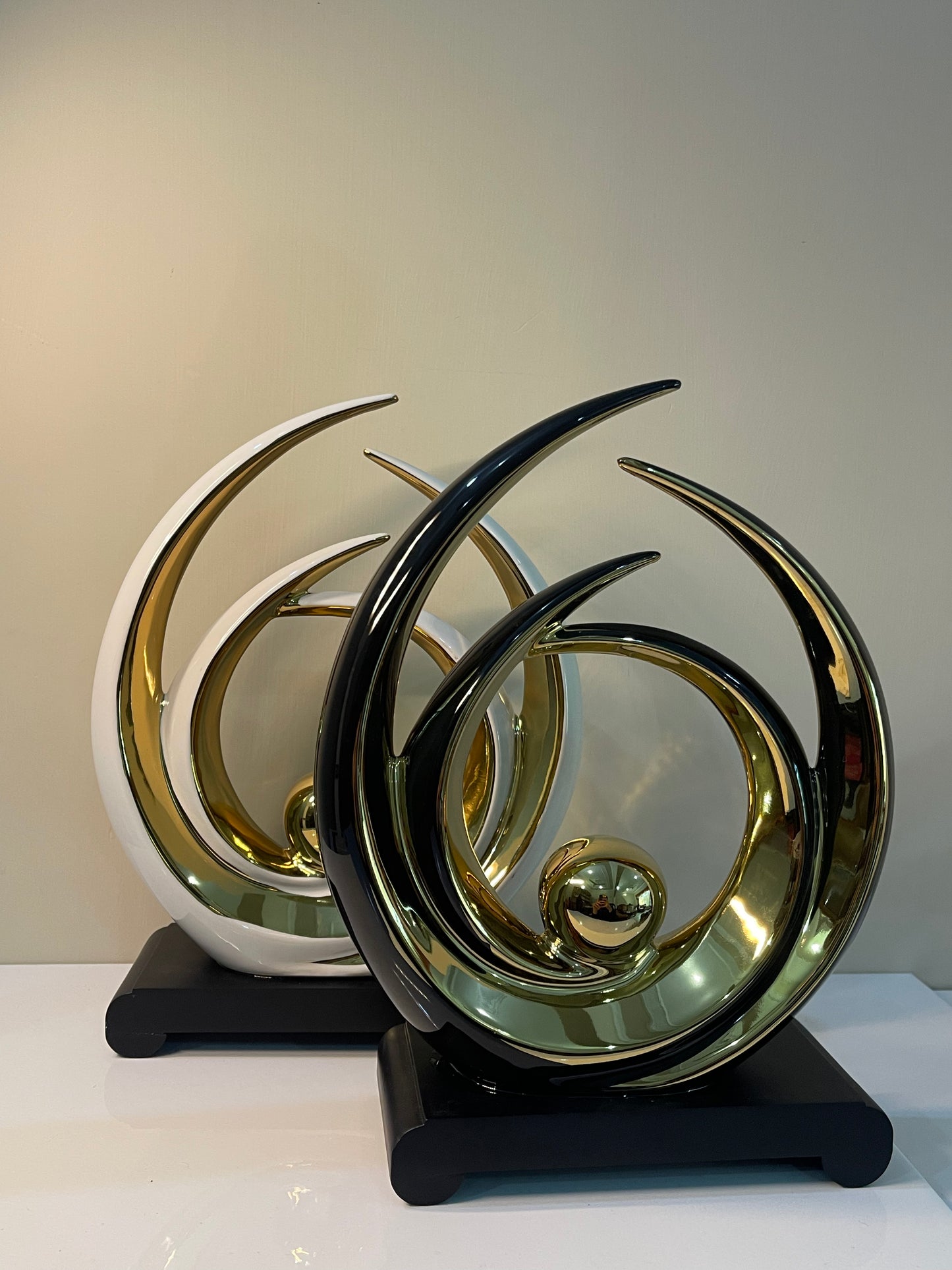 Gold-accented layered circle ornament with a black base and white outline, featuring overlapping circular designs.