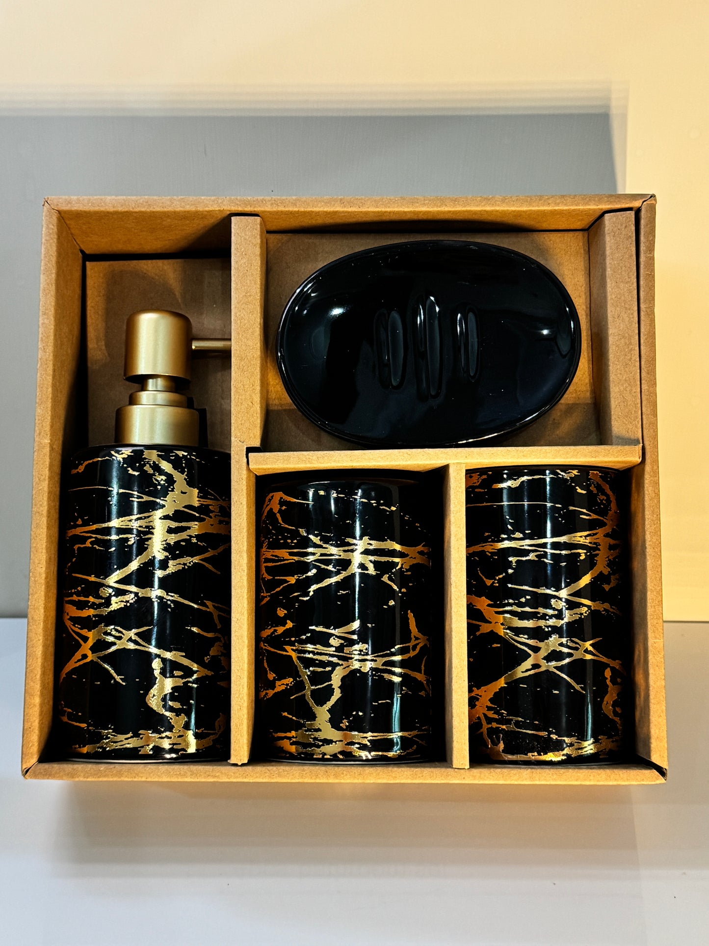 4-piece ceramic bathroom accessories set securely packaged in a sturdy box, showcasing the glossy black and gold designs.