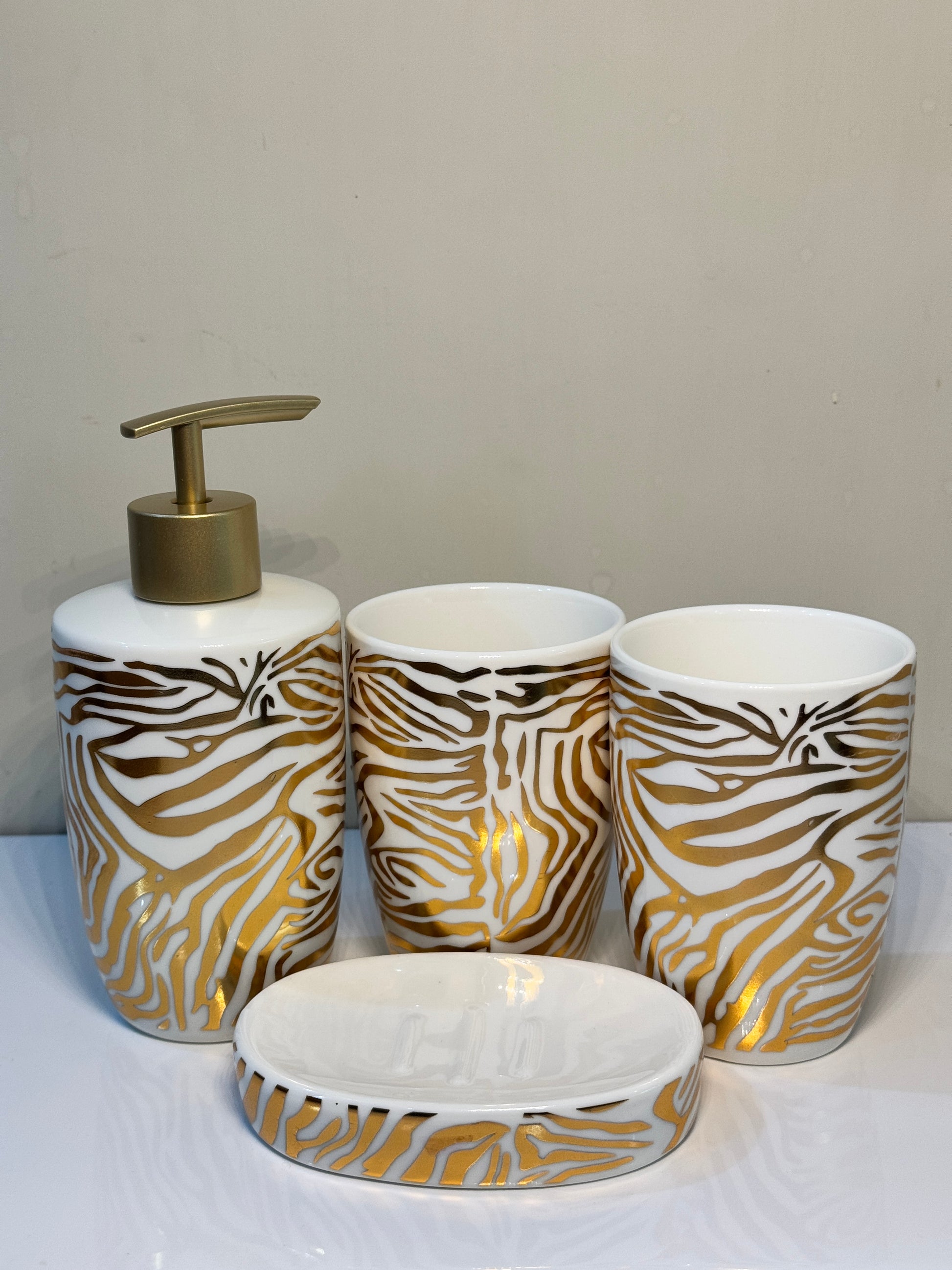 4-piece tiger print ceramic bathroom set in glossy black, including soap dispenser, tumbler, toothbrush holder, and soap dish.