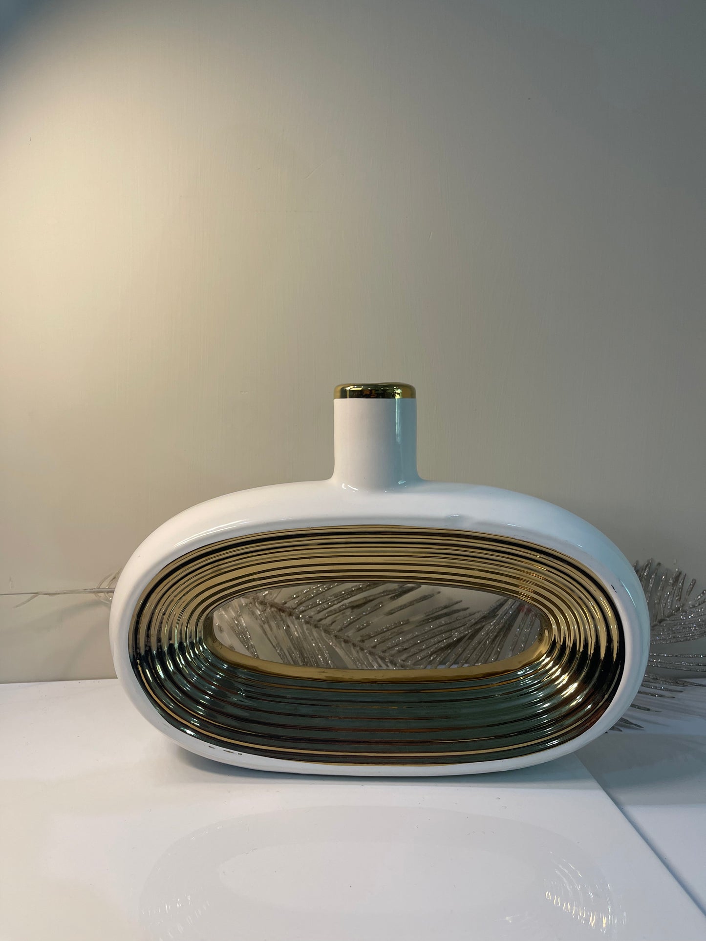 A gracefully curved oval vase, designed with soft contours and a subtle sheen, ideal for showcasing floral arrangements.