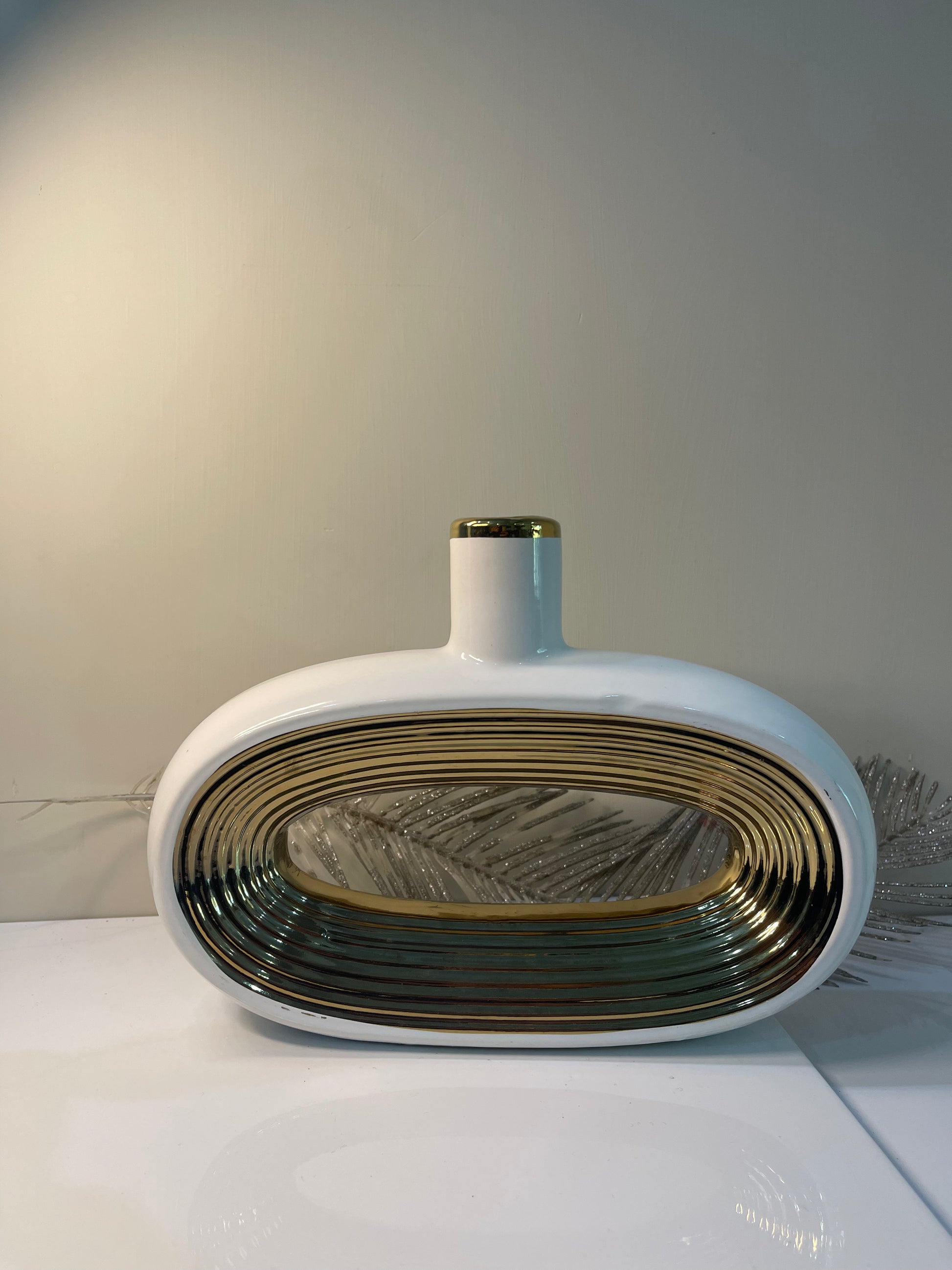 A gracefully curved oval vase, designed with soft contours and a subtle sheen, ideal for showcasing floral arrangements.