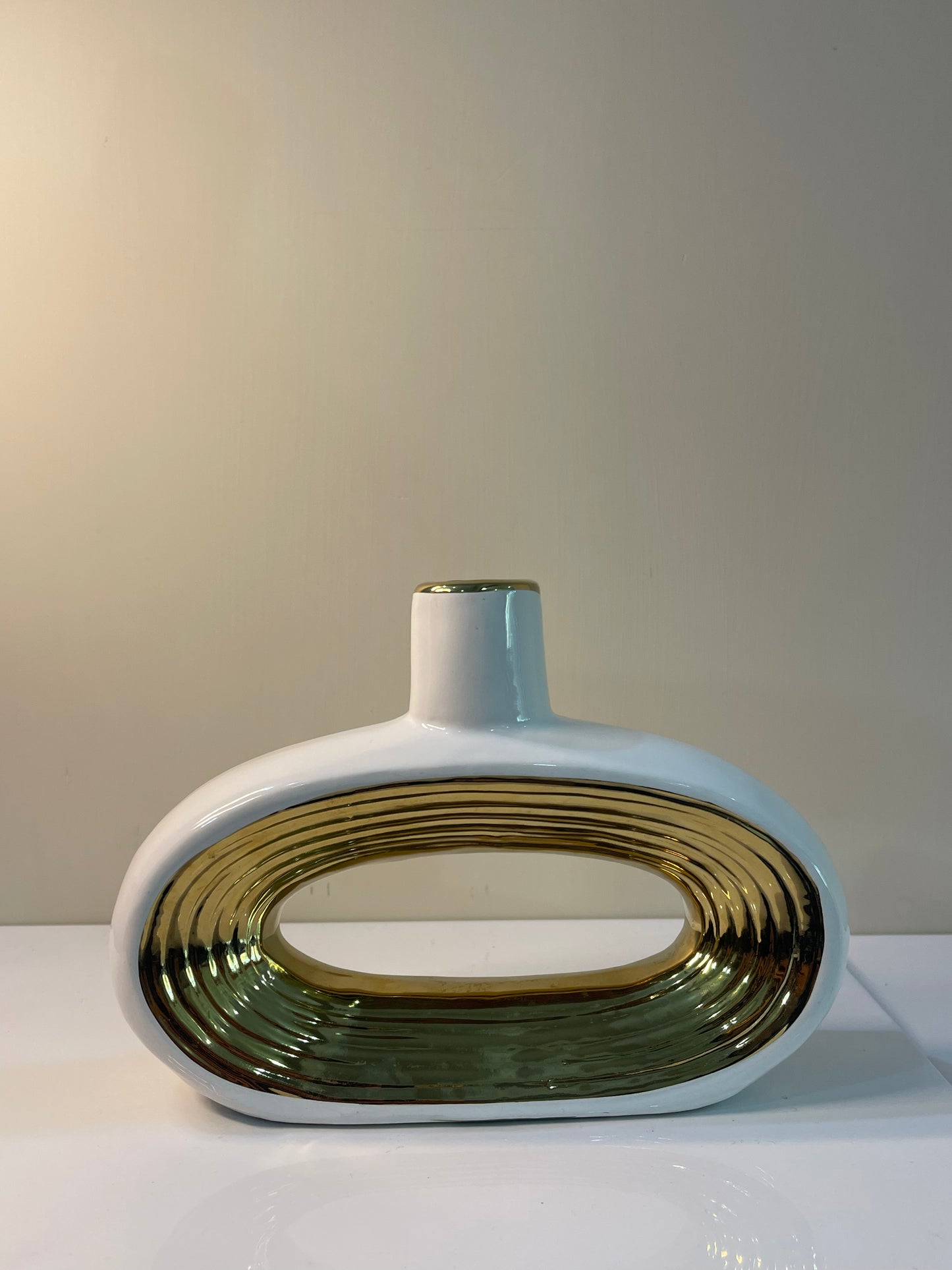 An elegant, rounded vase with an elongated oval shape, featuring a glossy finish that enhances its timeless beauty.