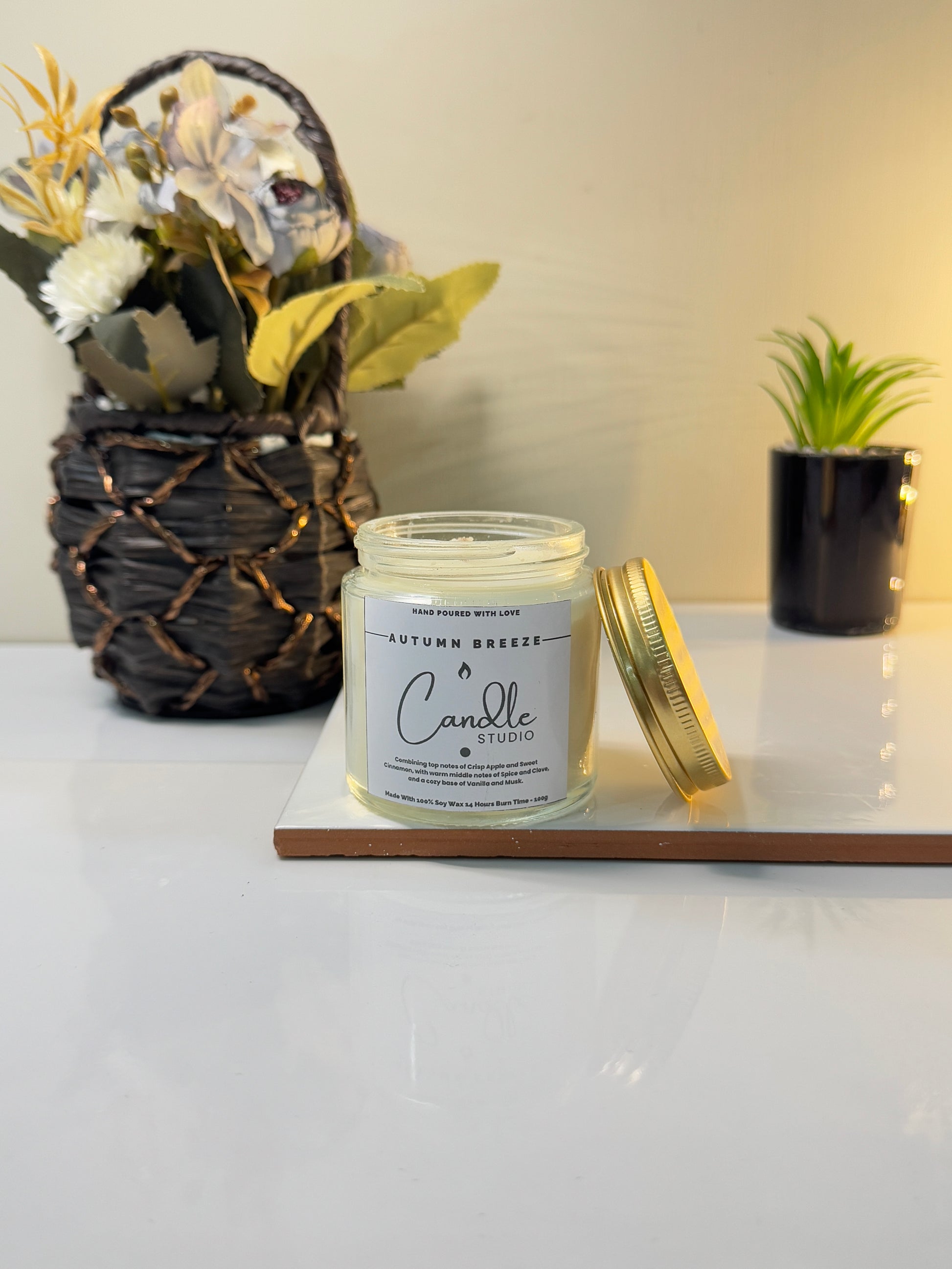 Autumn Breeze candle in a sleek jar, showcasing its warm and inviting design.