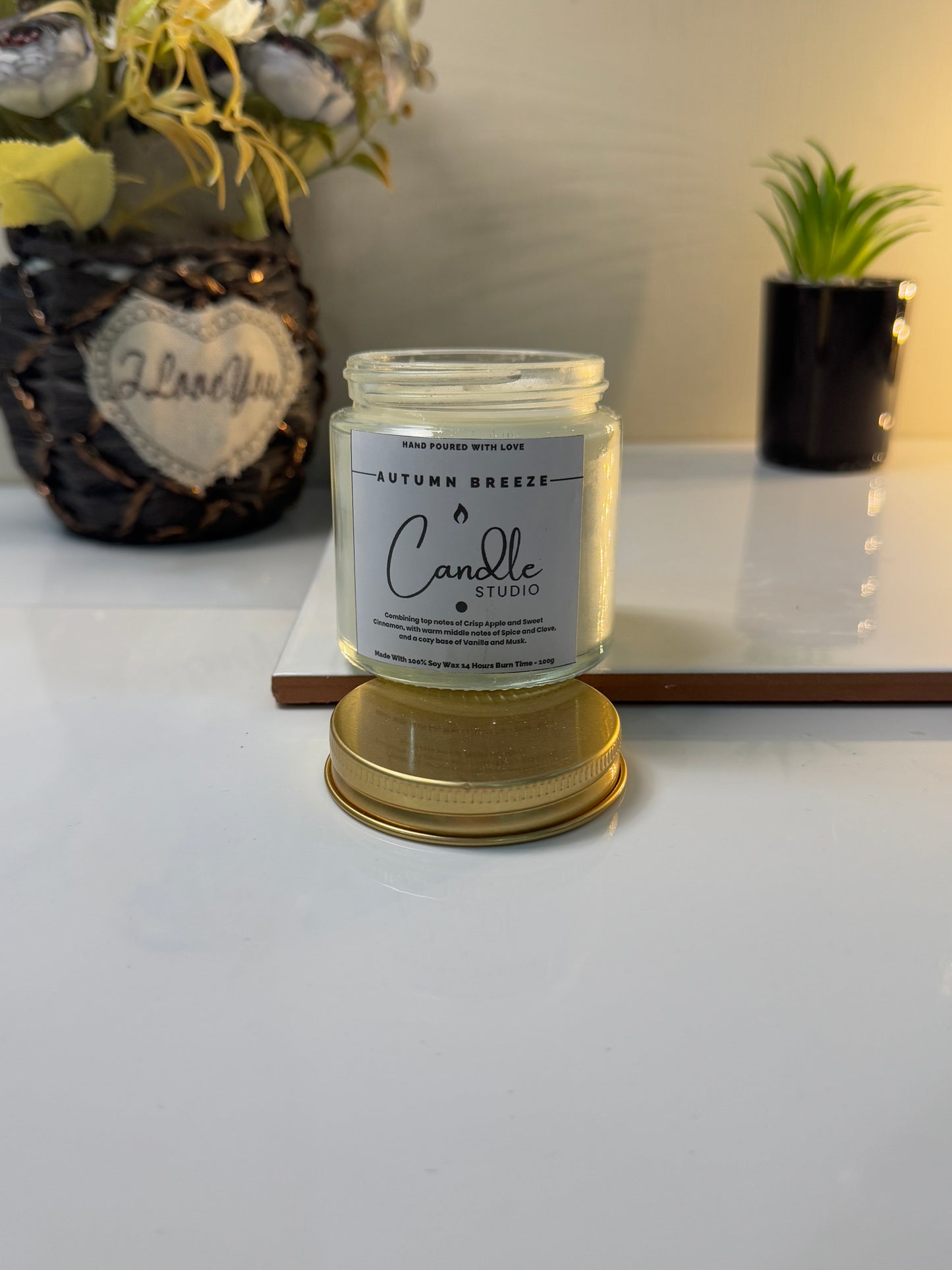 Autumn Breeze candle styled on a rustic table, evoking the essence of cozy autumn evenings.