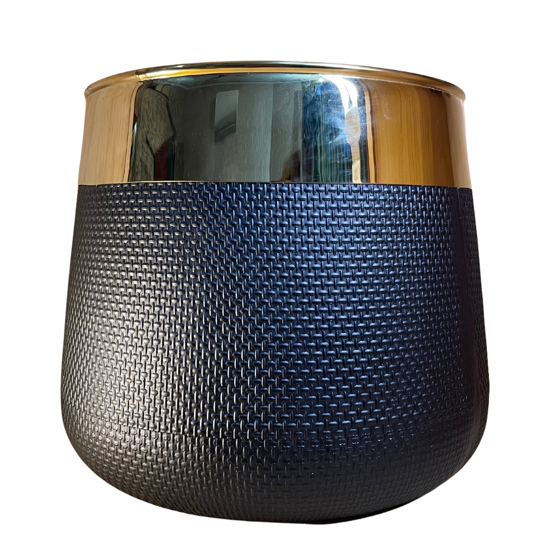 Black fiber flower pot used as an outdoor planter on a patio with colorful flowers.