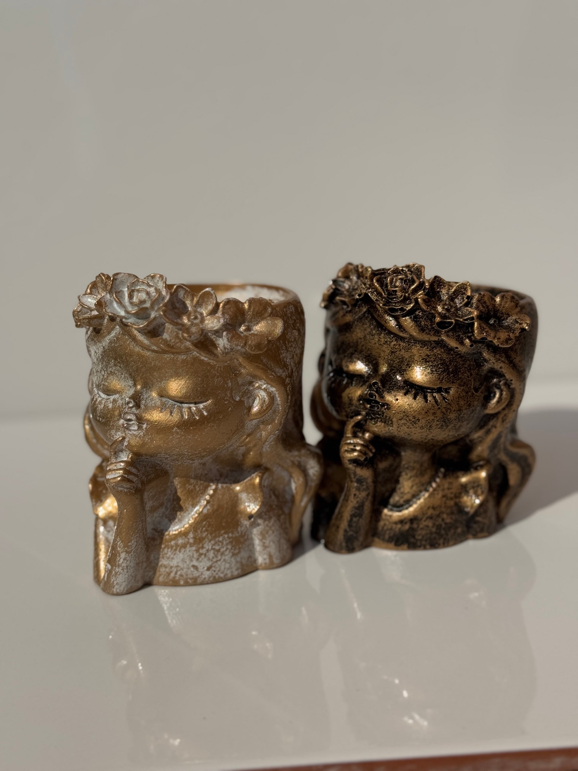 Close-up of aged stone Flower Girl Planter with a modern artistic design.