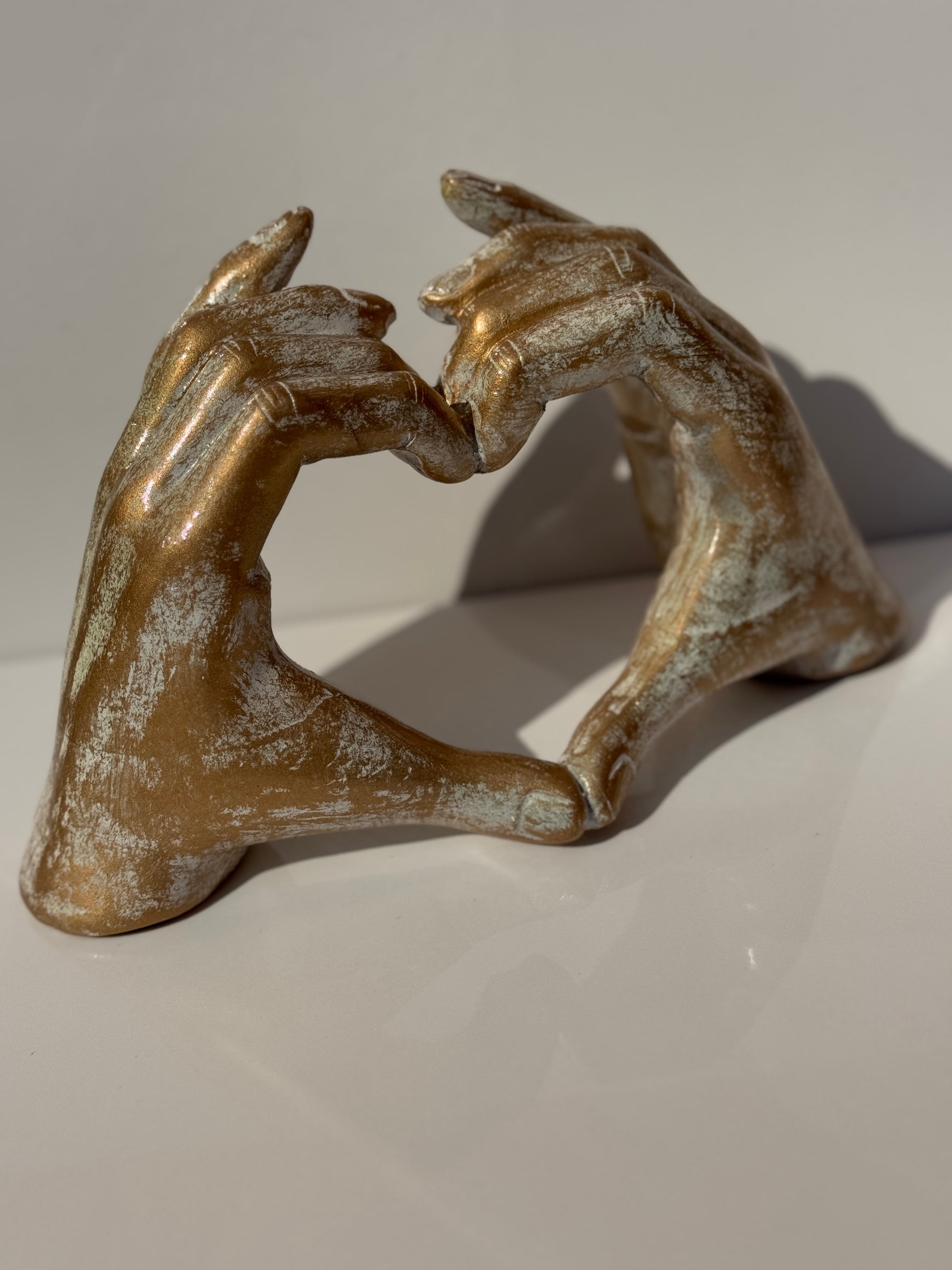 Close-up of the Love Sign Figure in gold, symbolizing love and connection.