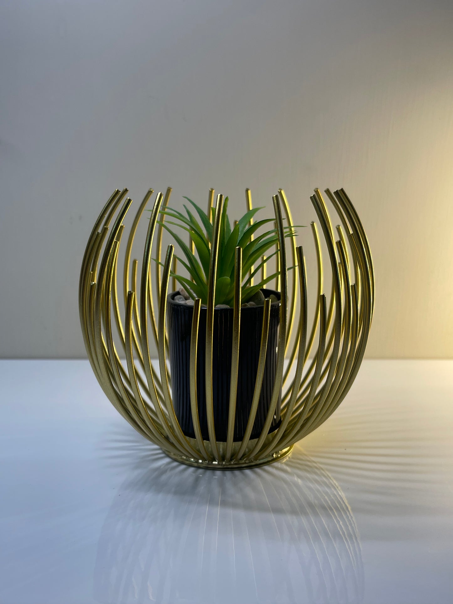 Close-up of the gold finish and removable pot inside the globe planter.
