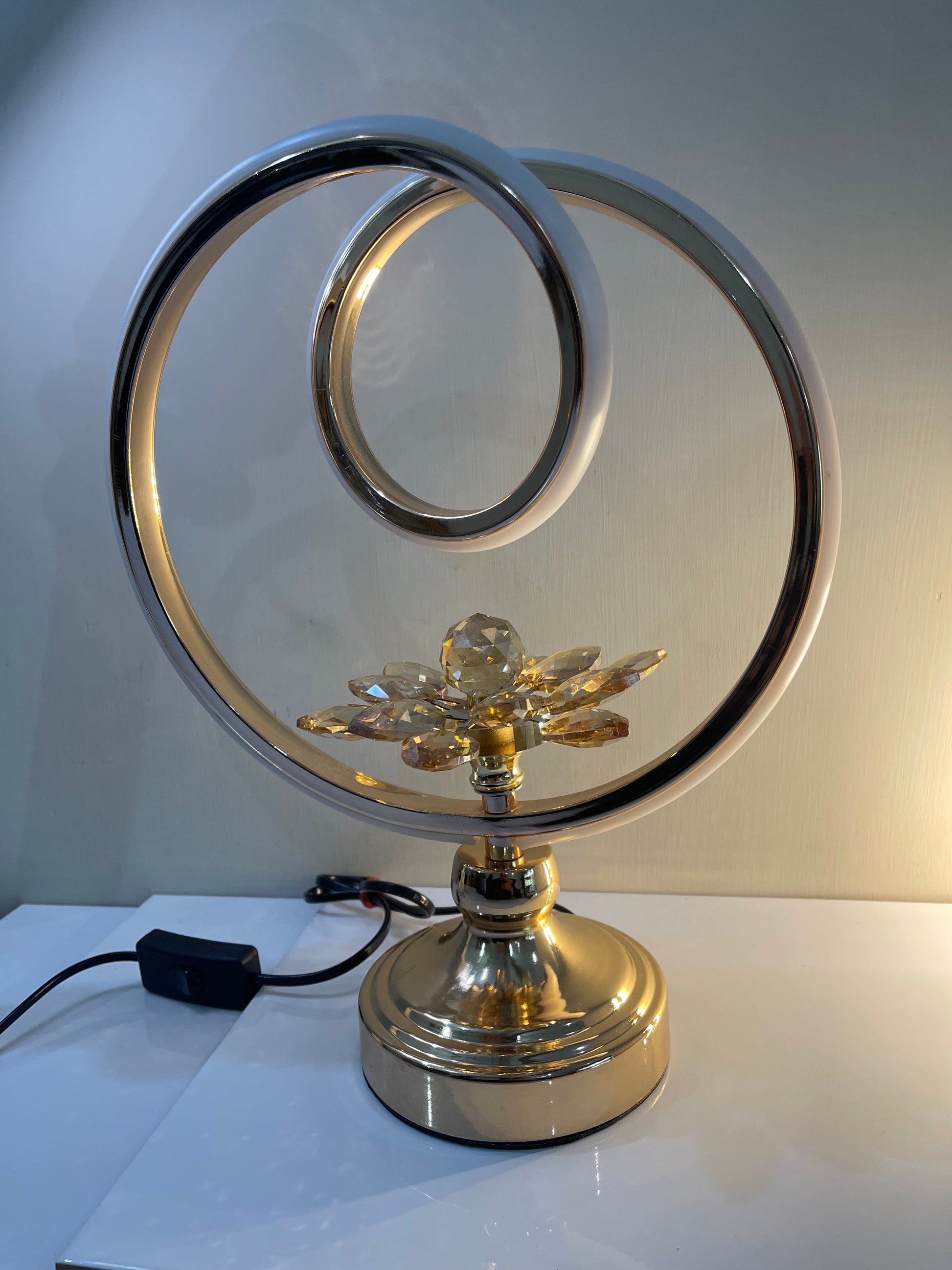 Close-up of the intricate flower design at the base of the circle lamp.