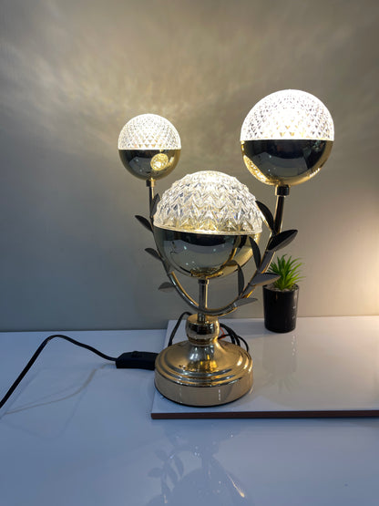 Close-up view of the three crystal balls and leaf detailing on the wavy stand, highlighting the intricate design.