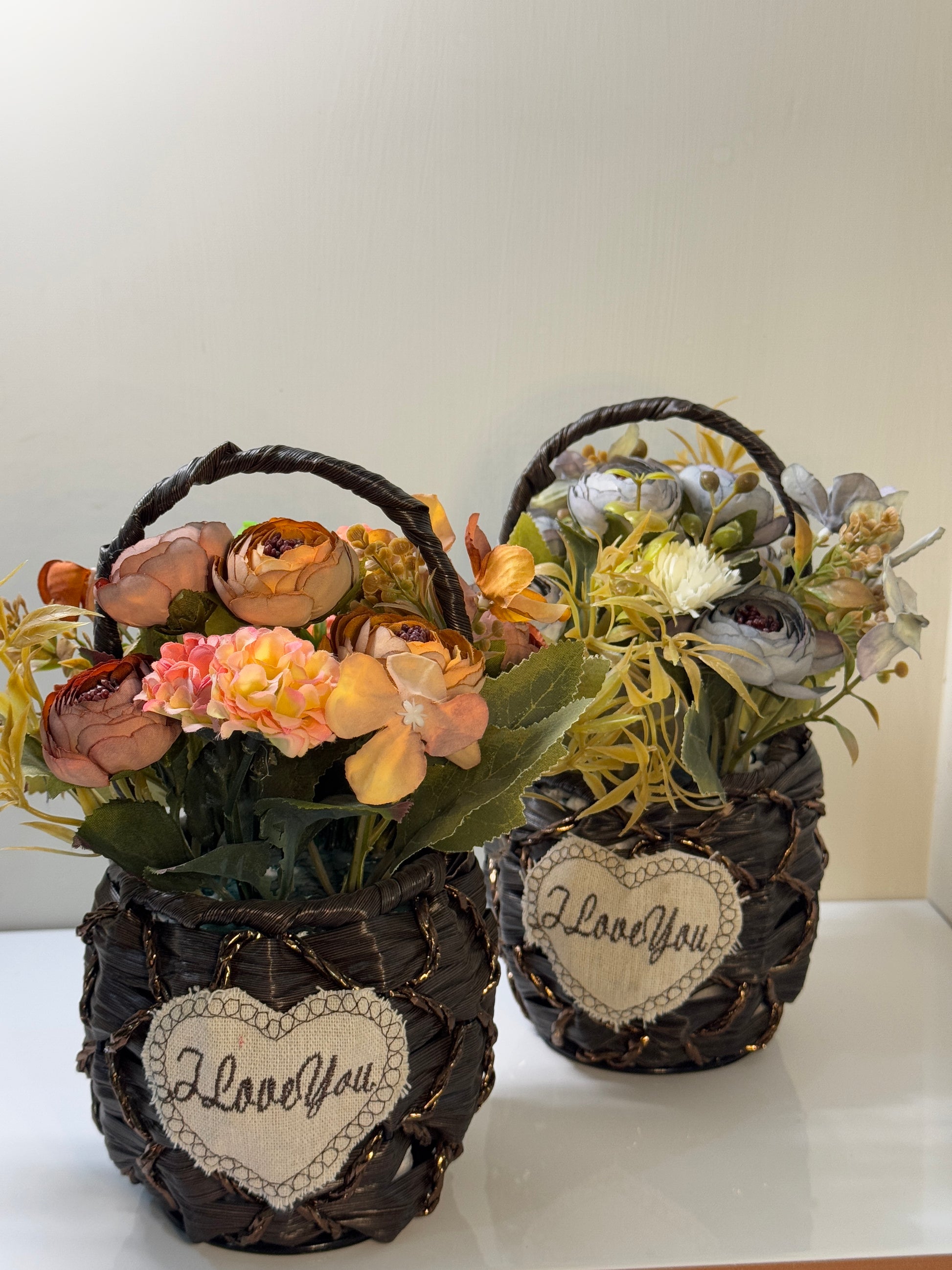 Cute flower basket featuring a variety of artificial flowers arranged in a small round-shaped woven basket