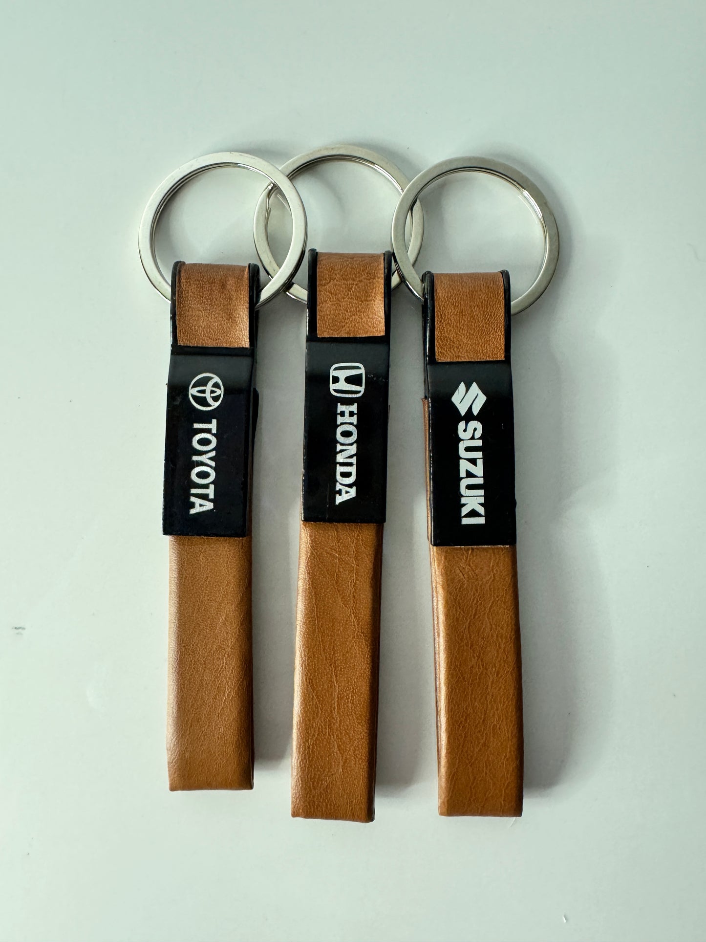 Discover durable Straight Line Metal Leather Keychains for Honda, Suzuki, and Toyota at Tech Car Home Pakistan. Sleek design, perfect for everyday use.