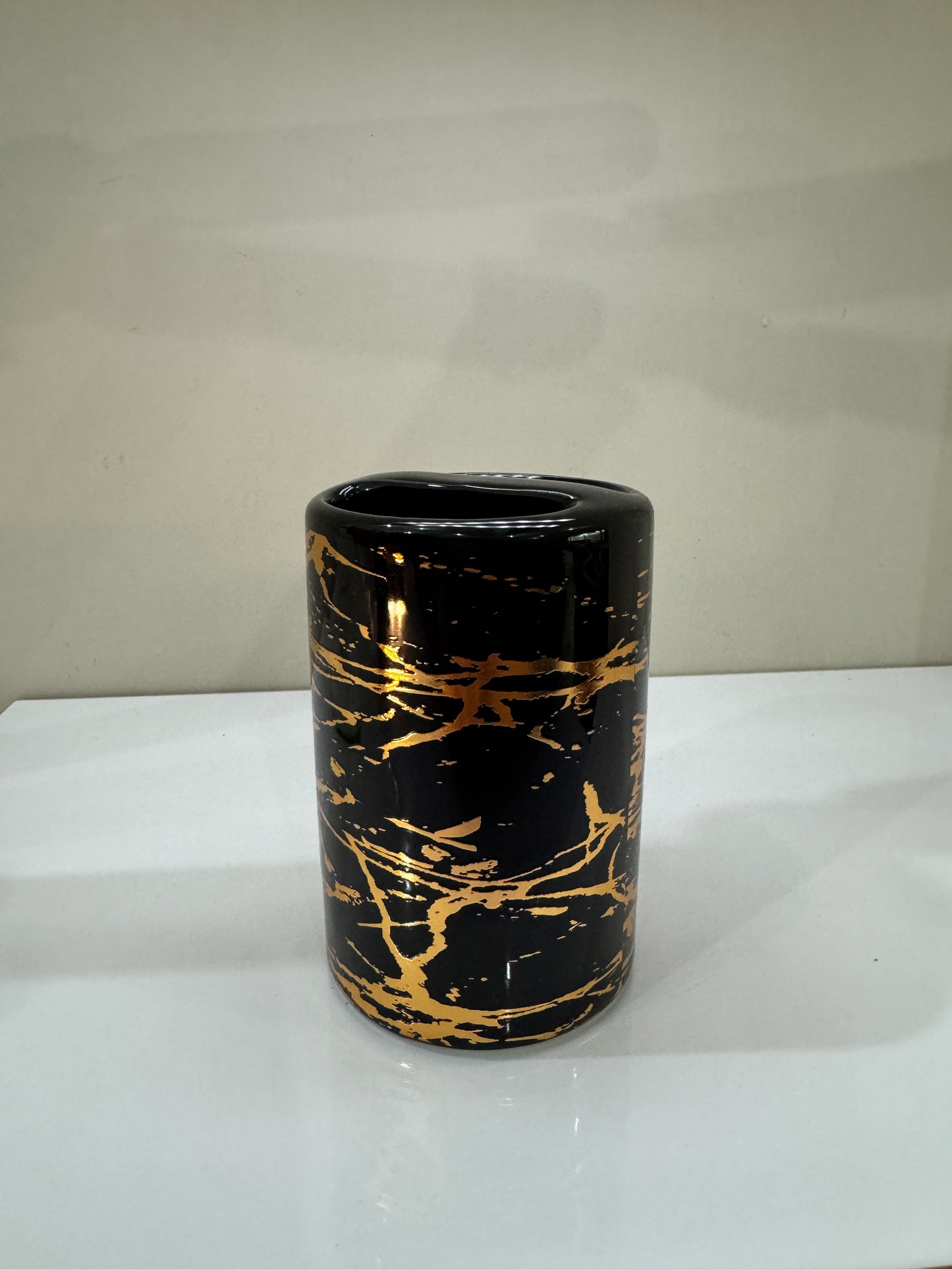 Elegant ceramic toothbrush holder with multiple compartments, featuring a glossy finish.