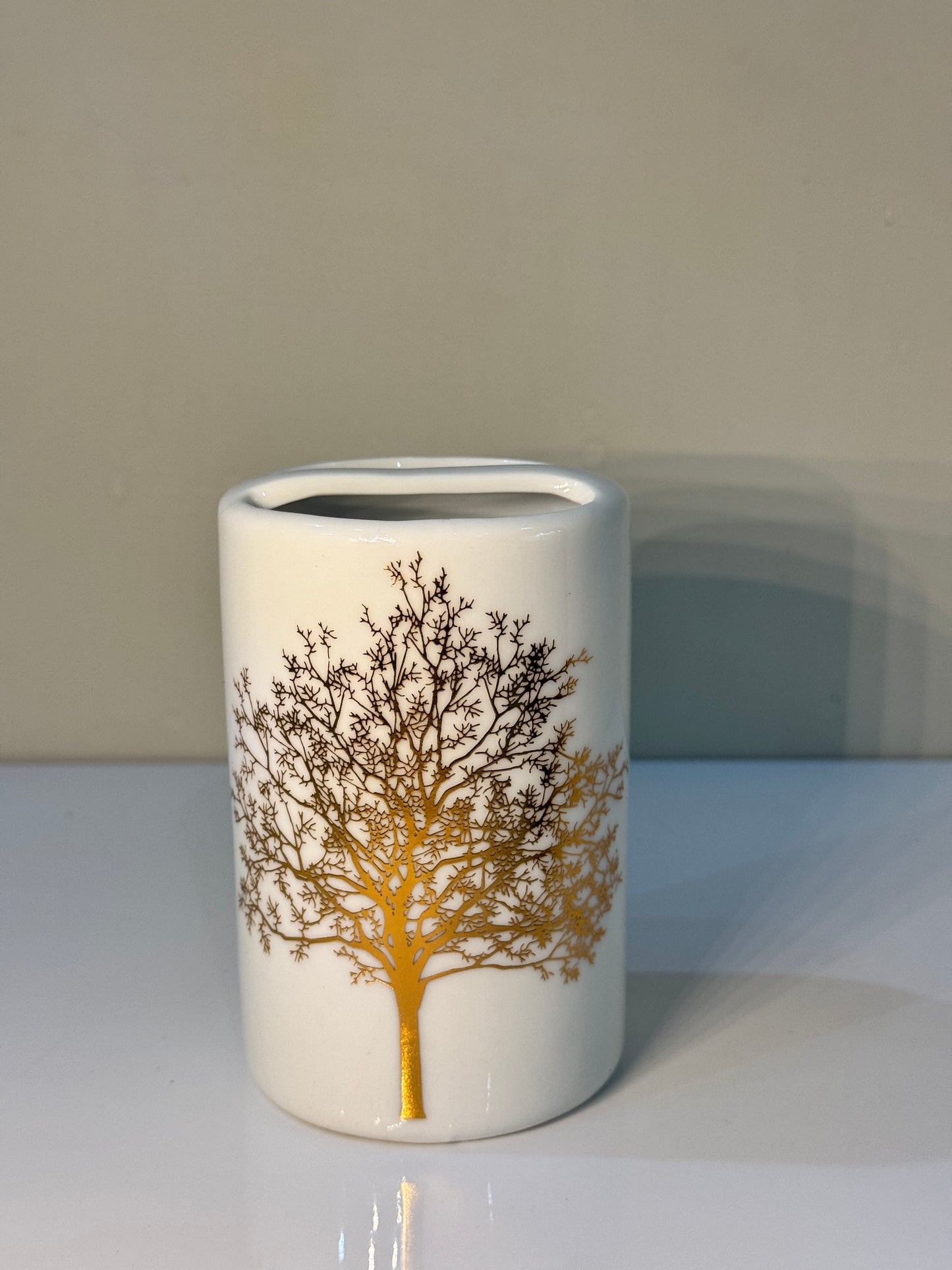 Elegant round toothbrush holder in white and gold ceramic, part of the 4-piece bathroom set.