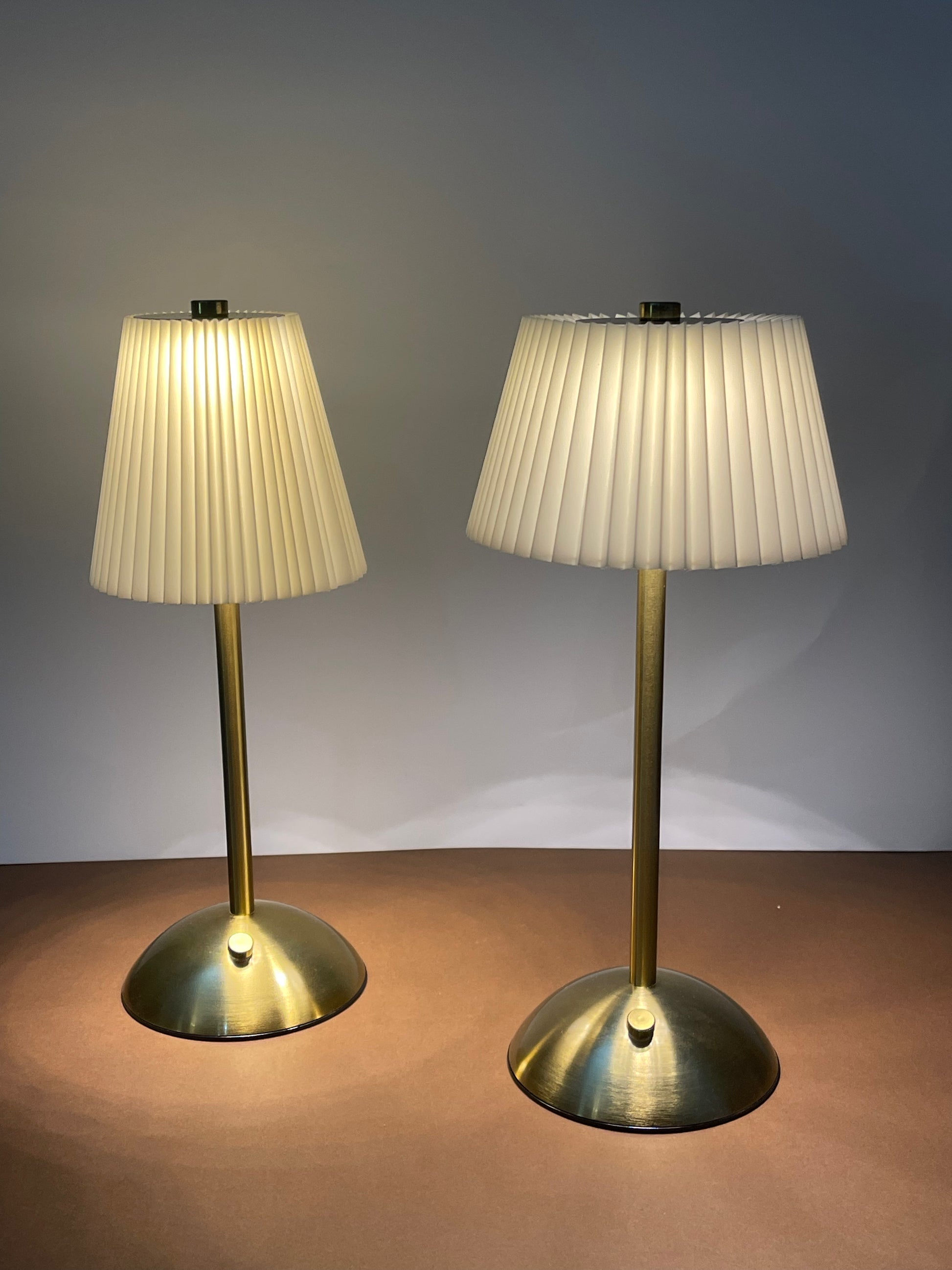 Elegant table lamp with a white pleated shade and a sleek metallic base, perfect for bedside decor.