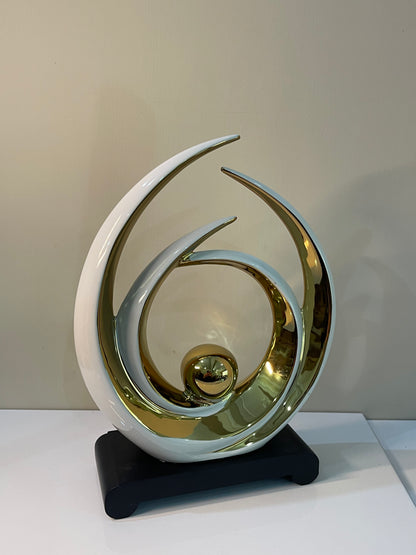 Elegant table ornament with a gold ball centerpiece, surrounded by overlapping white and black circular layers.