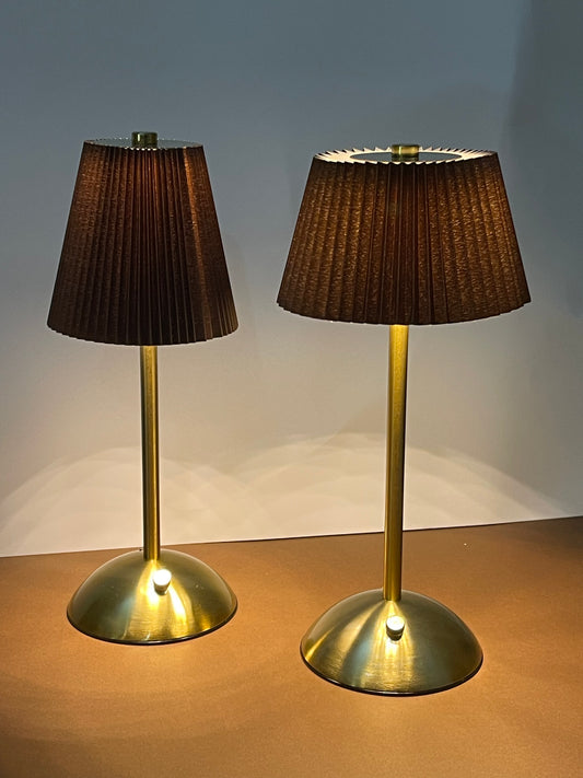 Luxury golden table lamp with pleated brown shade on a marble side table.
