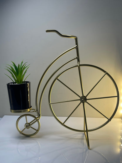 Metallic cycle planter holding a small plant, showcasing its modern style.