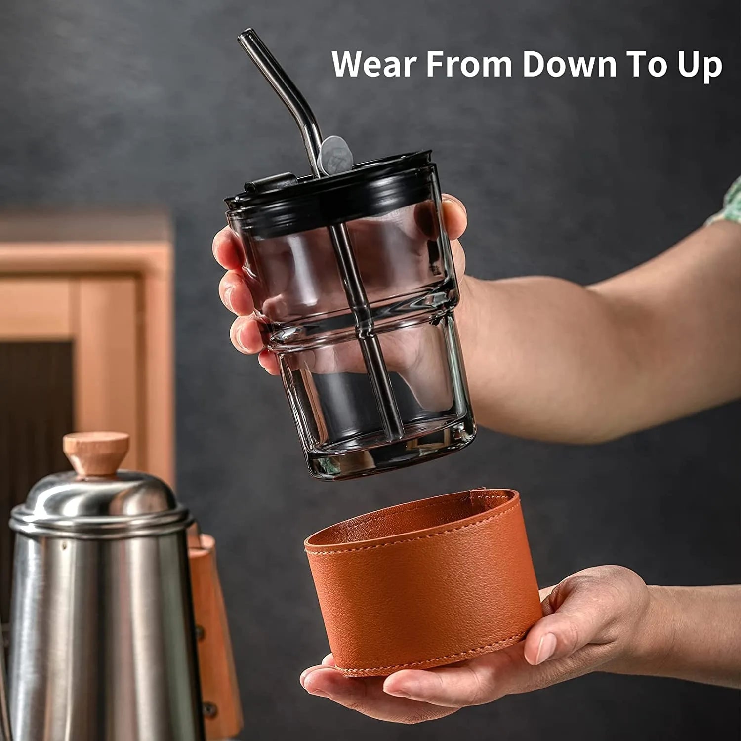 Person holding the Leather Covered Glass Cup, showing comfort and a stylish grip