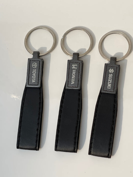 Premium black leather keychain with embossed Suzuki, Toyota, and Honda logos, offering a stylish and durable accessory.