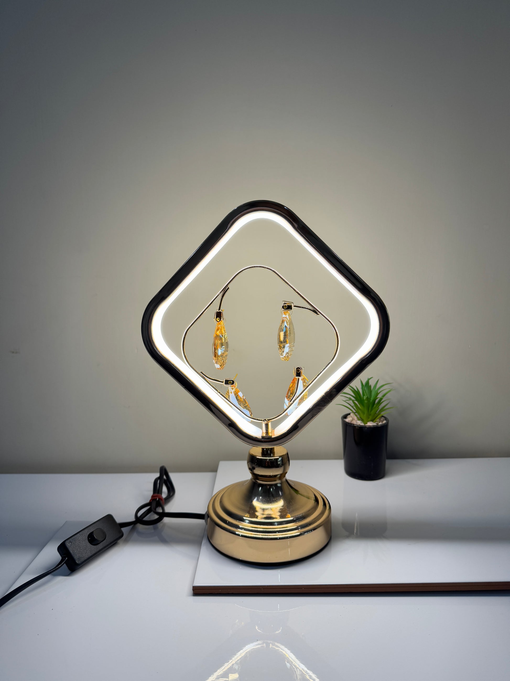 Radiant crystal square lamp with dangling gems, showcasing its modern and elegant design.