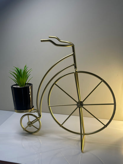 Side view of the metallic golden cycle planter with unique cycle-inspired design.
