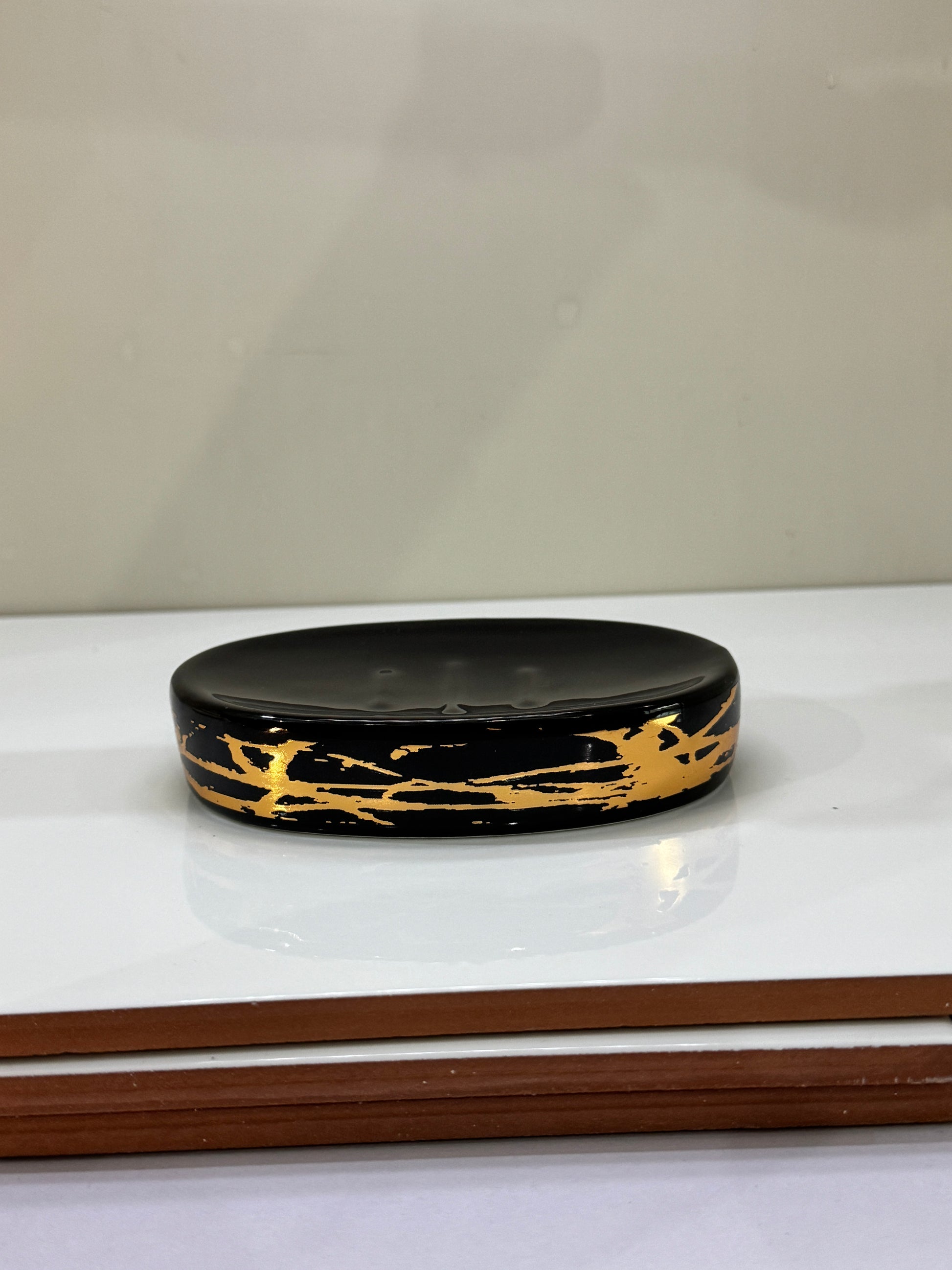 Stylish ceramic soap dish with a glossy black and gold design, part of the 4-piece bathroom set.