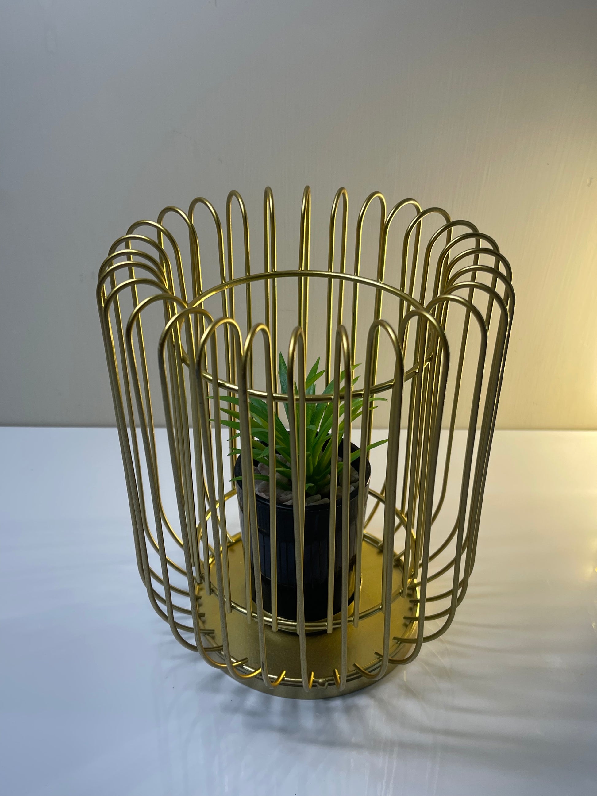 Top-down view of the gold planter stand with artificial succulent.
