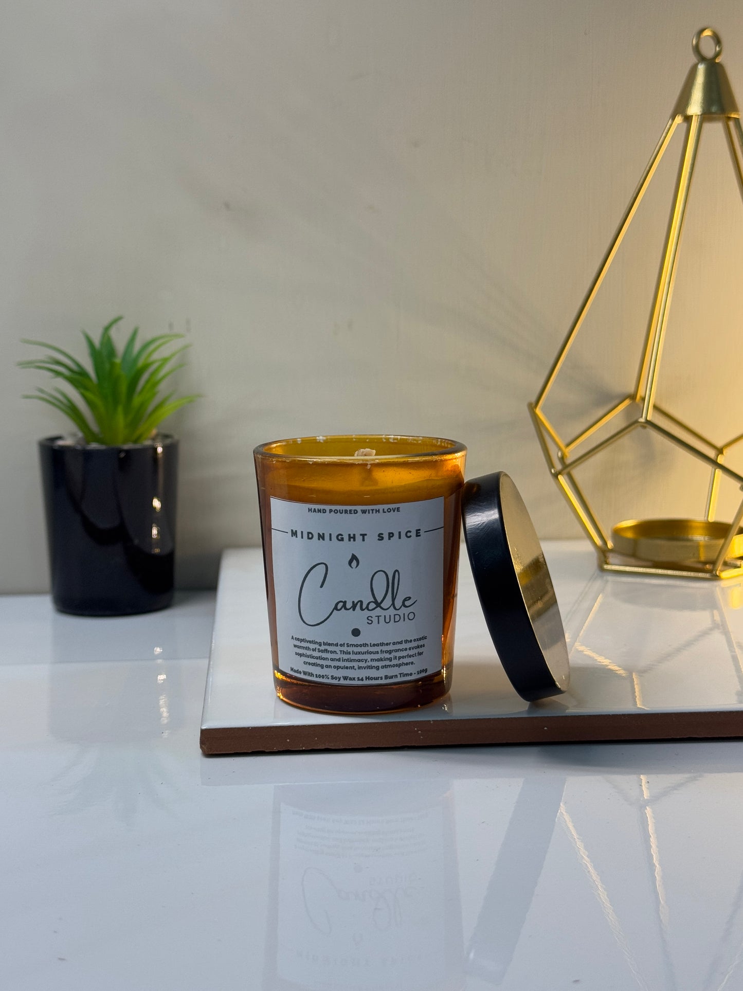 Unlit Midnight Spice candle in its sleek jar, showcasing the rich, dark wax and elegant design.