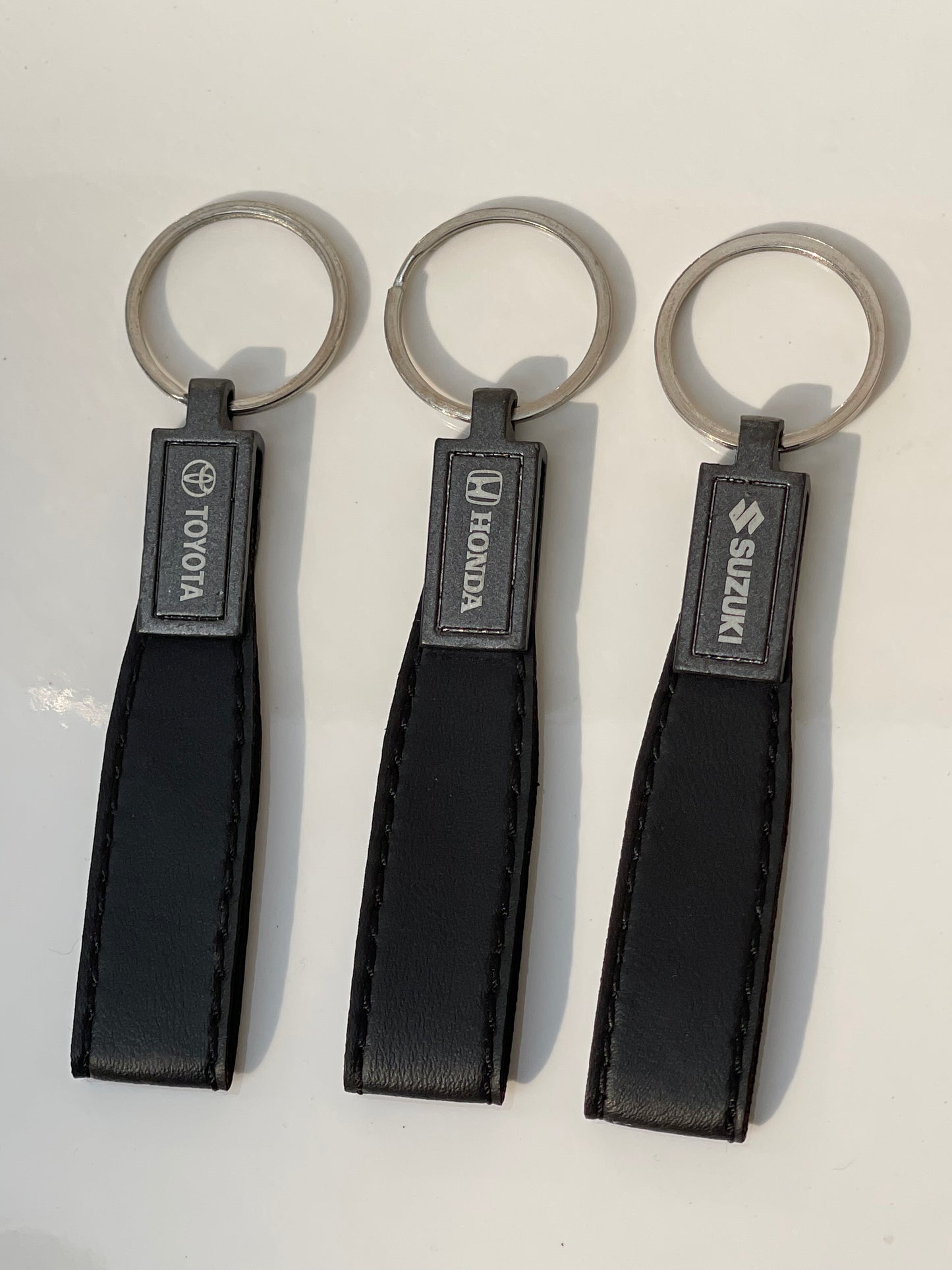 image of keychains with logo on honda, toyota, suzuki, premium quality in black color