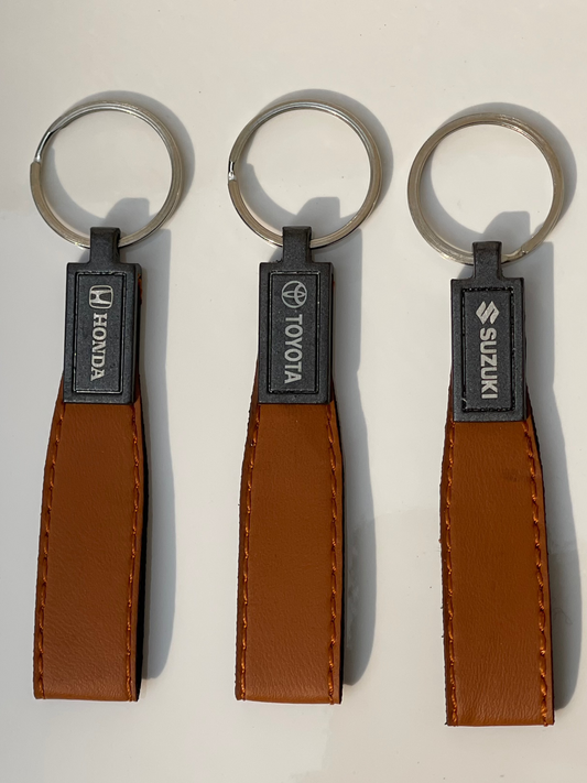 Premium brown leather keychain featuring Suzuki, Toyota, and Honda logos. High-quality design for durability and elegance