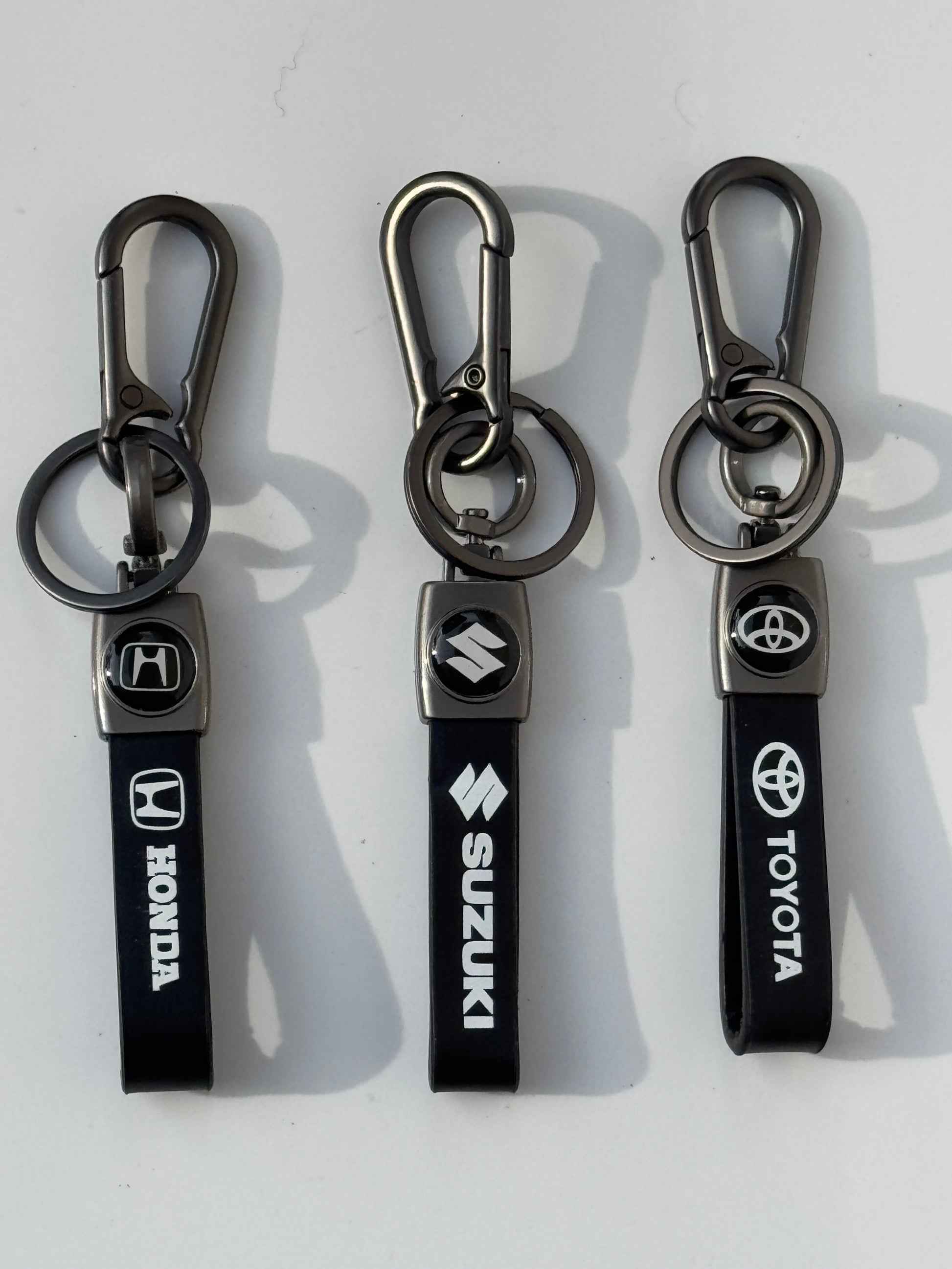 Close-up of high-quality double logo keychains featuring Honda, Toyota, and Suzuki logos, crafted for a premium design and sleek look.